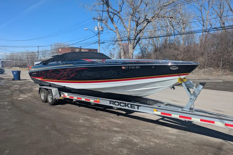 The Image of 2008 Formula 292 FASTech boat on trailer, black with red accents, parked outdoors. - 0