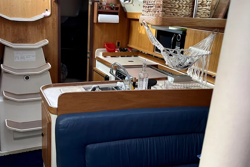 Slide: The Image of Interior of 2001 Catalina 380 sailboat with kitchen and seating area. - 11