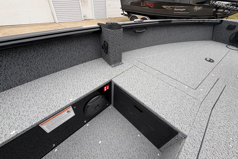 Slide: The Image of 2026 Lund 1700 Explorer SS boat interior with storage compartments and speaker. - 17
