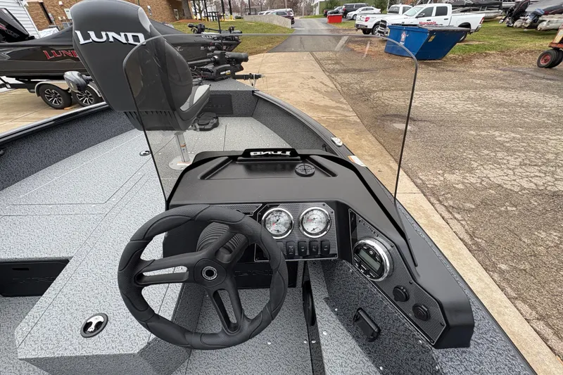 Slide: The Image of 2026 Lund 1700 Explorer SS boat interior with steering wheel and dashboard controls. - 19