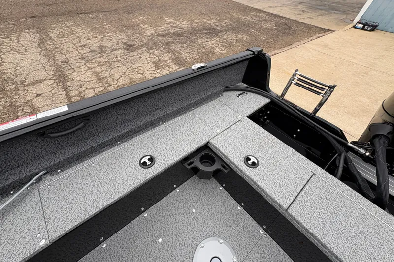 Slide: The Image of 2026 Lund 1700 Explorer SS boat interior with gray textured flooring and storage compartments. - 21