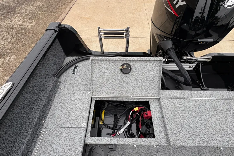 Slide: The Image of 2026 Lund 1700 Explorer SS boat interior with open storage compartment and Mercury engine. - 24