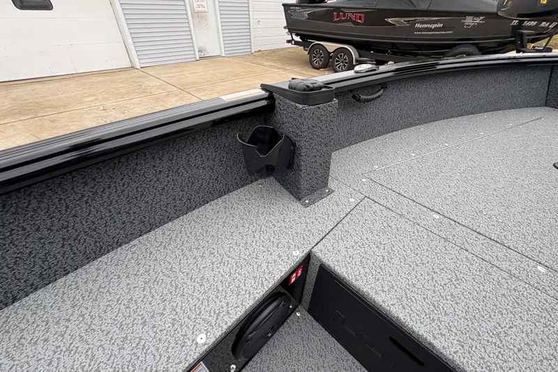 Slide: The Image of 2026 Lund 1700 Explorer SS boat interior with gray textured flooring and storage compartments. - 29