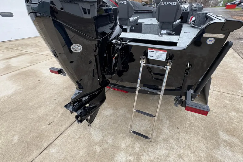 Slide: The Image of 2026 Lund 1700 Explorer SS boat with motor and ladder on concrete surface. - 32