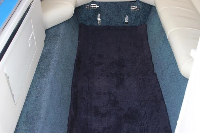 Slide: The Image of Interior cabin of a 2000 Fountain 32 Fever boat with blue carpet and white seating. - 12