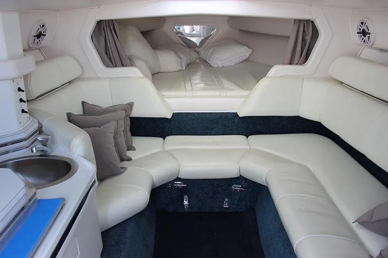 Slide: The Image of Interior of 2000 Fountain 32 Fever boat with white leather seating and compact kitchenette. - 15