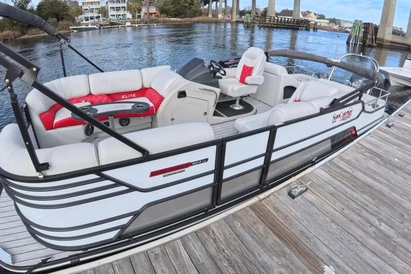 Slide: The Image of 2025 SunCatcher ELITE SERIES 324 SS pontoon boat docked by the water. - 14