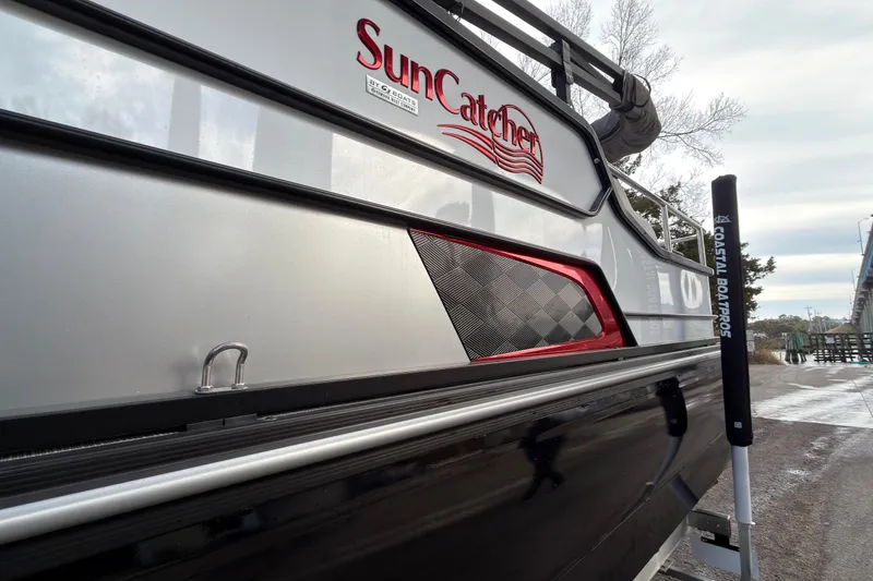 Slide: The Image of 2025 SunCatcher ELITE SERIES 324 SS boat, sleek design, docked outdoors. - 19