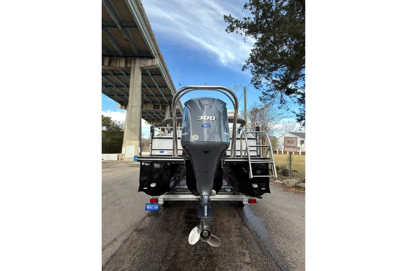 Slide: The Image of 2025 SunCatcher ELITE SERIES 324 SS boat with powerful outboard motor, parked under a bridge. - 23