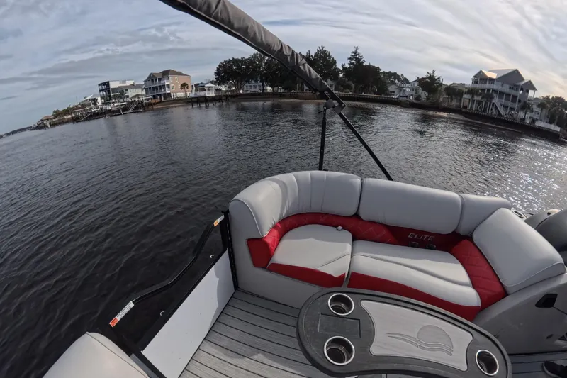 Slide: The Image of Luxury SunCatcher ELITE SERIES 324 SS pontoon boat interior, 2025 model, on serene waterfront. - 24