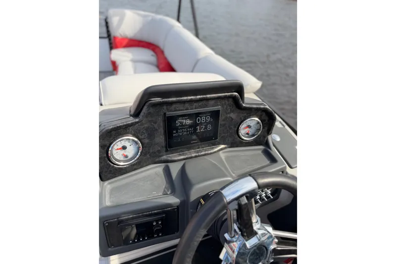 Slide: The Image of 2025 SunCatcher ELITE SERIES 324 SS dashboard with gauges and steering wheel on water. - 27