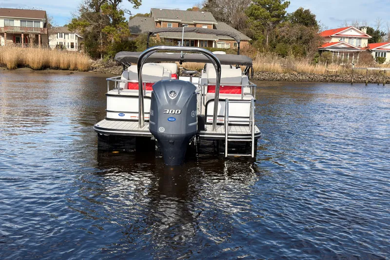 Slide: The Image of 2025 SunCatcher ELITE SERIES 324 SS pontoon boat on calm water, rear view. - 3