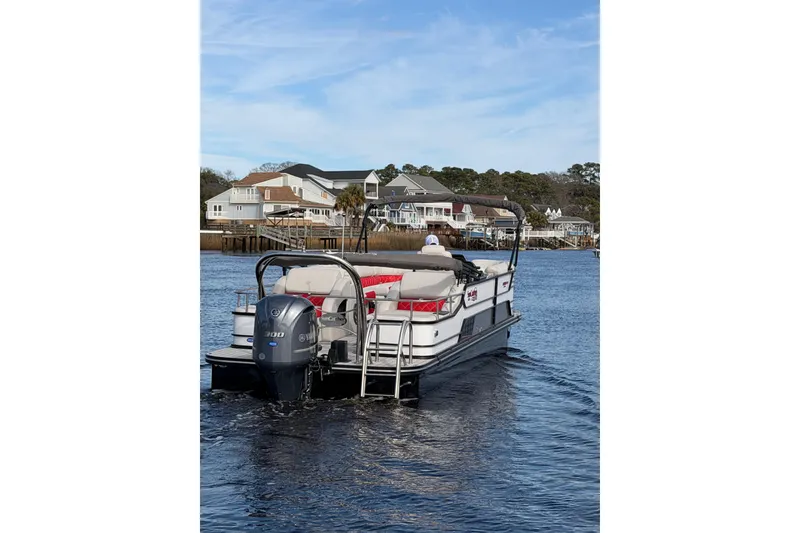 Slide: The Image of 2025 SunCatcher ELITE SERIES 324 SS pontoon boat on water near residential area. - 5