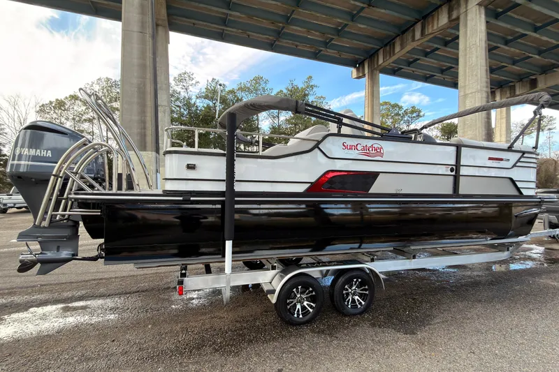 Slide: The Image of 2025 SunCatcher ELITE SERIES 324 SS pontoon boat on trailer under bridge. - 6