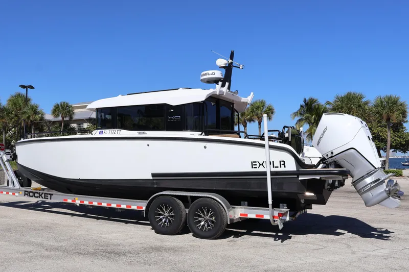 Slide: The Image of 2024 XO Boats EXPLR 10 S Plus on trailer, parked outdoors under clear blue sky. - 10