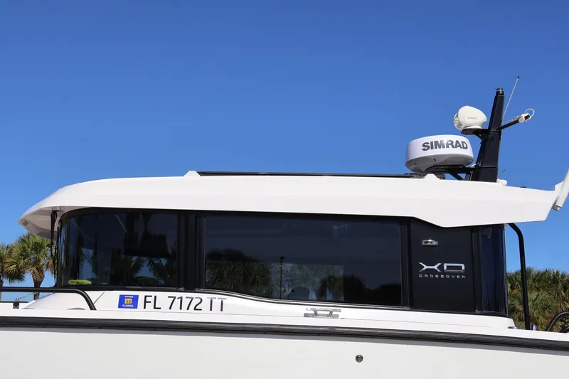 Slide: The Image of 2024 XO Boats EXPLR 10 S Plus with Simrad radar, side view against blue sky. - 12