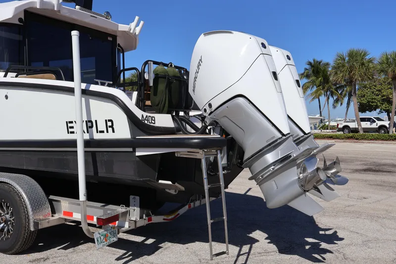 Slide: The Image of 2024 XO Boats EXPLR 10 S Plus with dual Mercury outboard engines on a trailer. - 13