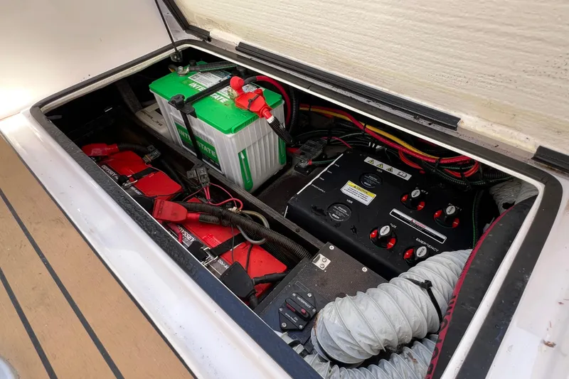 Slide: The Image of 2024 XO Boats EXPLR 10 S Plus battery compartment with wiring and control panel. - 29
