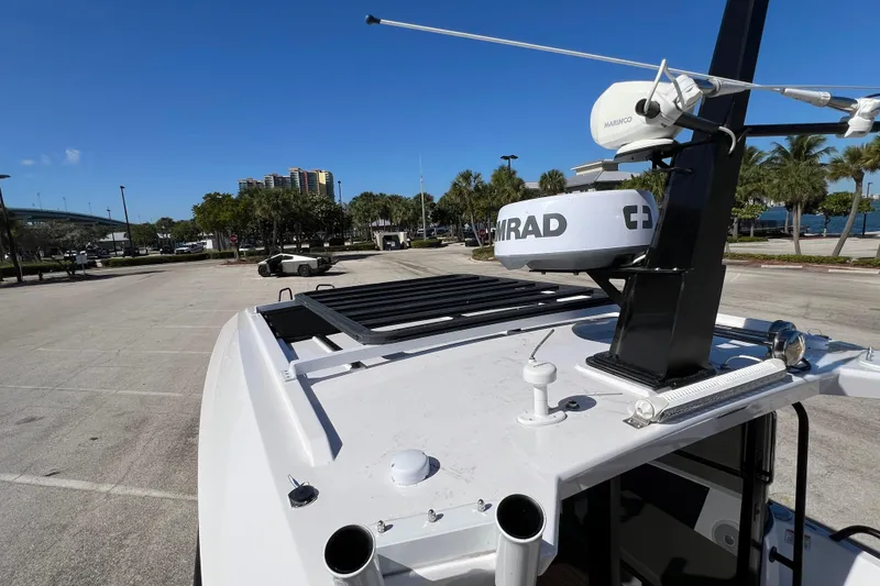 Slide: The Image of 2024 XO Boats EXPLR 10 S Plus with radar equipment, parked near waterfront. - 36