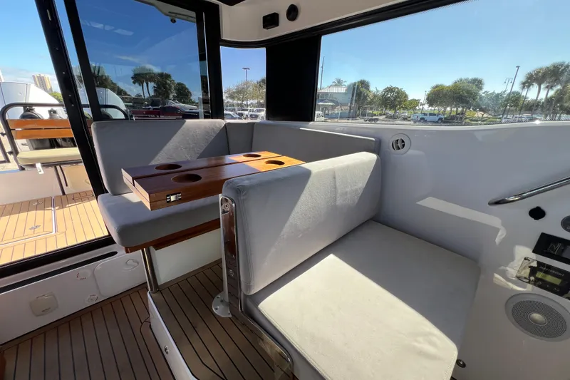 Slide: The Image of Interior of 2024 XO Boats EXPLR 10 S Plus with cushioned seating and wooden table. - 38