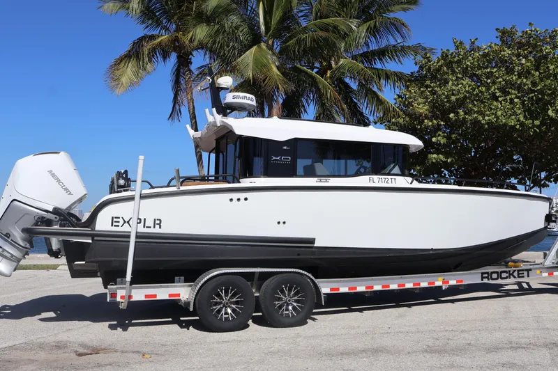 Slide: The Image of 2024 XO Boats EXPLR 10 S Plus on trailer, palm trees in background. - 4