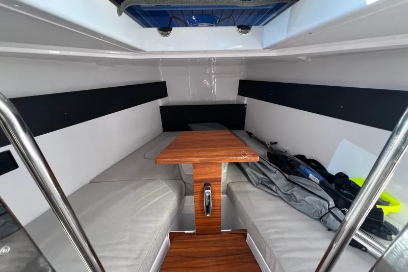 Slide: The Image of 2024 XO Boats EXPLR 10 S Plus cabin interior with wooden table and seating. - 62