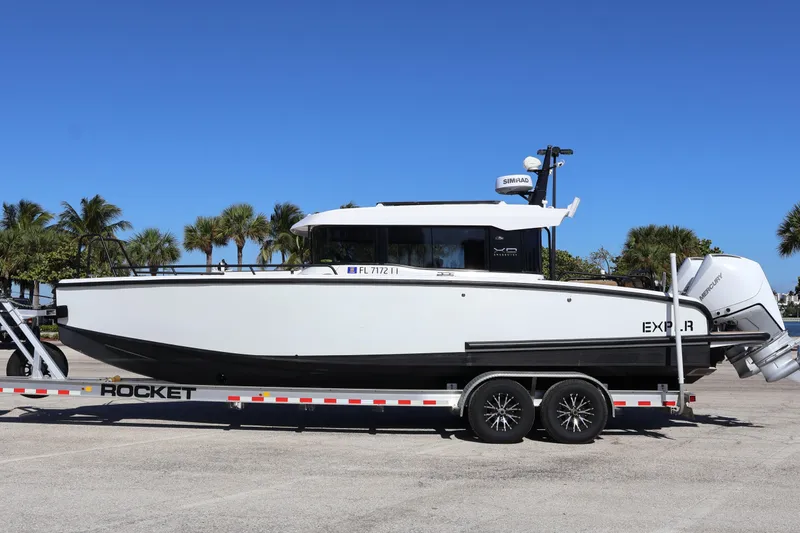 Slide: The Image of 2024 XO Boats EXPLR 10 S Plus on trailer, parked with palm trees in background. - 8