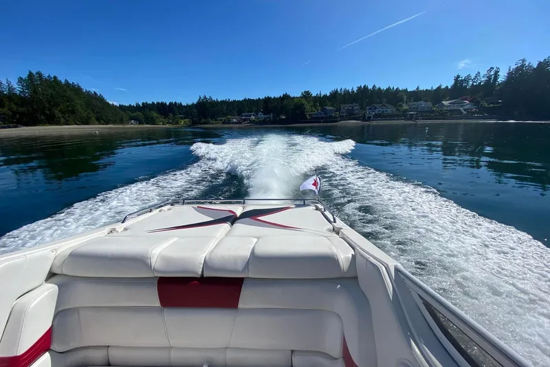 Slide: The Image of 2004 Fountain 38 Lightning speedboat cruising on a sunny lake with scenic shoreline. - 20