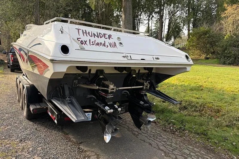 Slide: The Image of 2004 Fountain 38 Lightning boat on trailer, labeled "Thunder," parked on a wooded road. - 5
