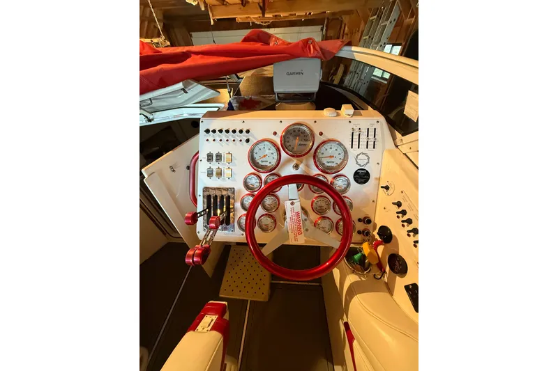 Slide: The Image of 2004 Fountain 38 Lightning boat dashboard with red accents and multiple gauges. - 7