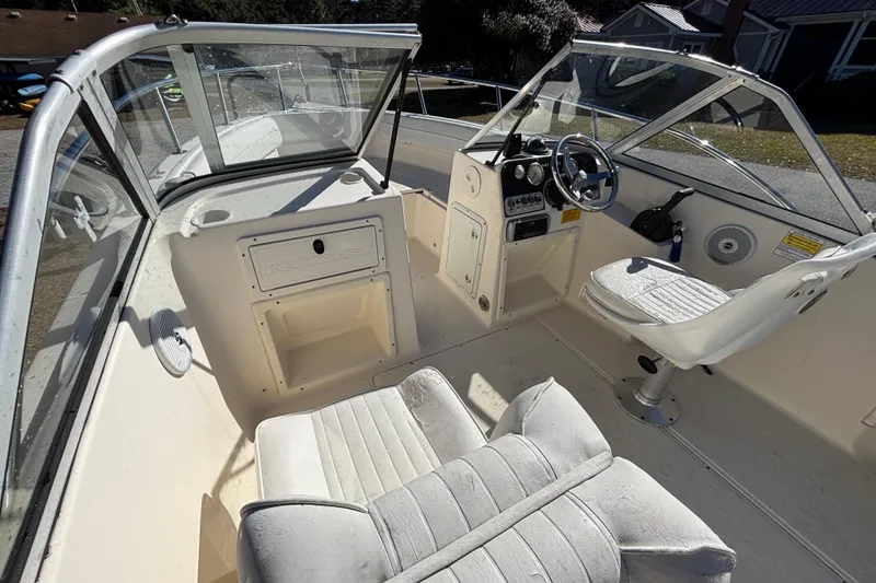 Slide: The Image of Interior of a 2004 Key West 2020 Dual Console boat, featuring seating and steering controls. - 13