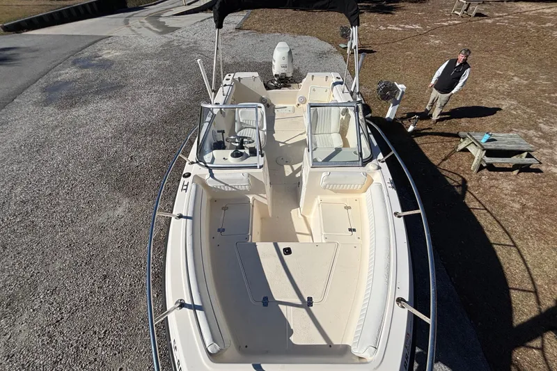 Slide: The Image of Key West 2020 Dual Console boat, 2004 model, parked on gravel with a person nearby. - 19