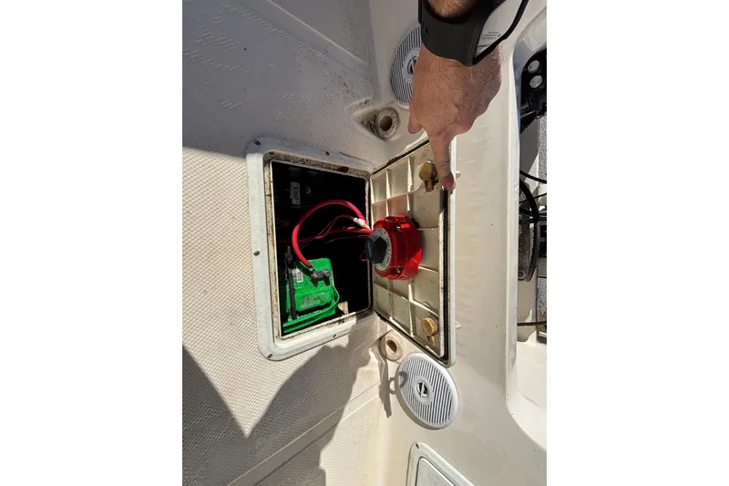Slide: The Image of Key West 2020 Dual Console 2004 boat battery compartment with red switch and wiring. - 24