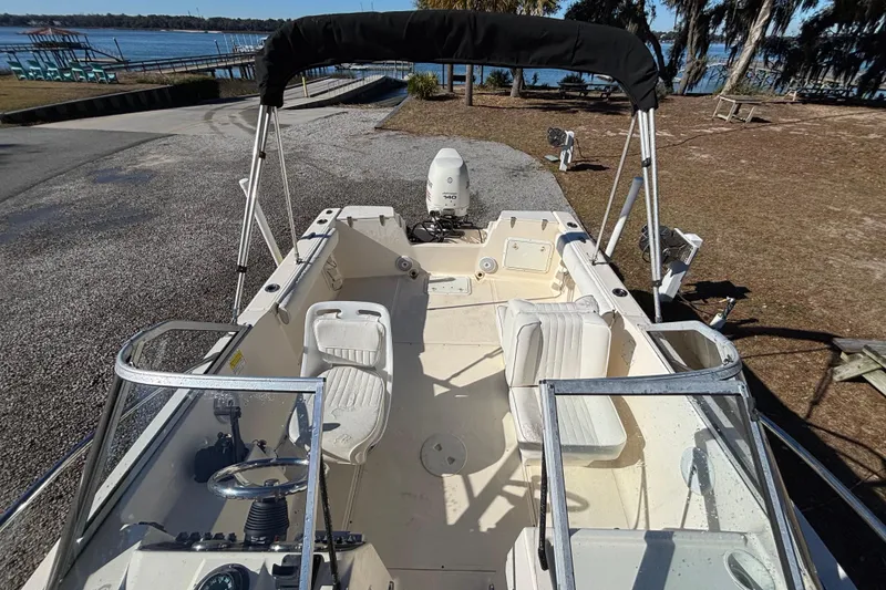 Slide: The Image of 2004 Key West Dual Console boat with seating, docked near a scenic lake. - 7