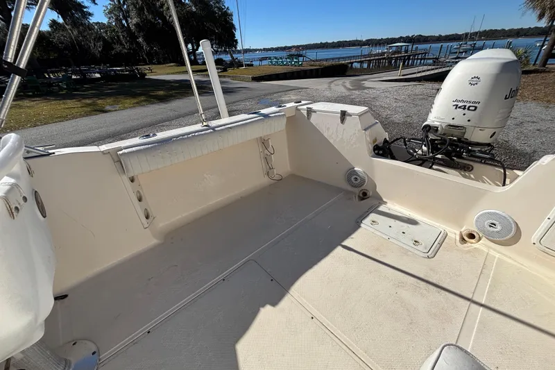 Slide: The Image of 2004 Key West Dual Console boat with Johnson 140 engine, docked by a scenic waterfront. - 9