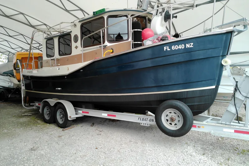 The Image of 2010 Ranger Tugs R-25 boat on trailer under canopy, side view. - 0