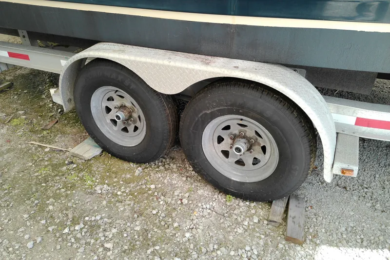 Slide: The Image of Trailer wheels of a 2010 Ranger Tugs R-25 boat on gravel. - 23