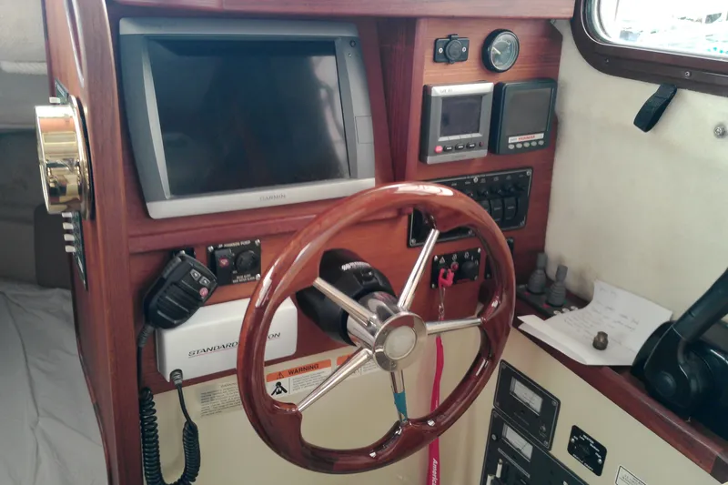 Slide: The Image of 2010 Ranger Tugs R-25 helm with wooden steering wheel and navigation equipment. - 32