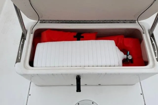 Slide: The Image of Open storage compartment on 2017 Boston Whaler 190 Montauk boat with life jackets and equipment. - 12