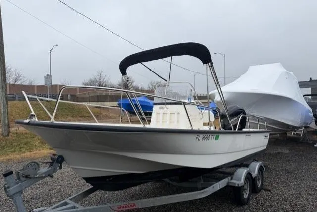 Slide: The Image of 2017 Boston Whaler 190 Montauk boat on trailer, parked outdoors on a cloudy day. - 2