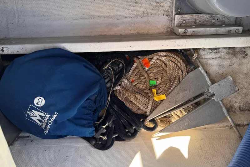 Slide: The Image of Storage compartment on a 1972 Gandy Flybridge with ropes, anchor, and blue cover. - 13