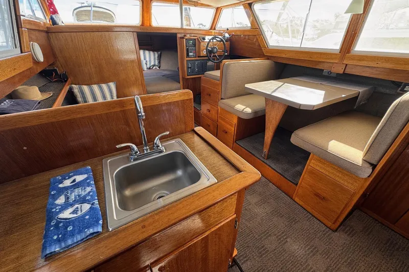 Slide: The Image of 1972 Gandy Flybridge interior with wooden finish, sink, and dining area. - 16