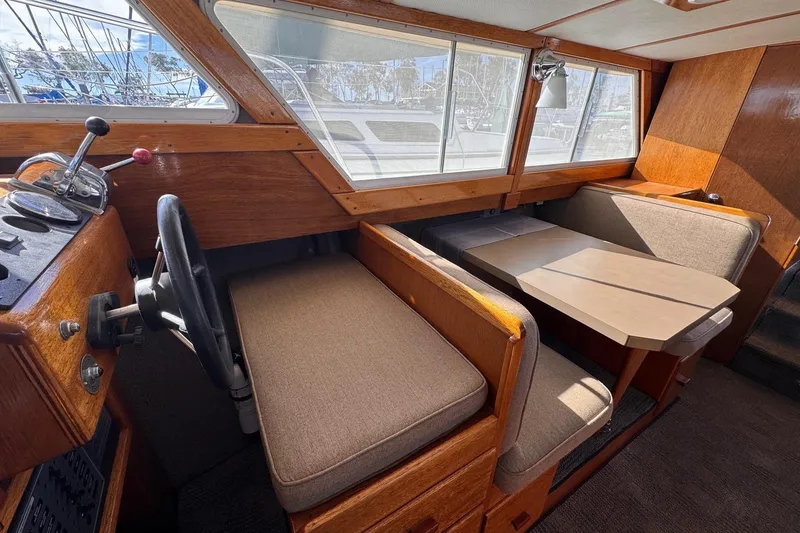Slide: The Image of Interior of a 1972 Gandy Flybridge boat with wooden helm and seating area. - 17
