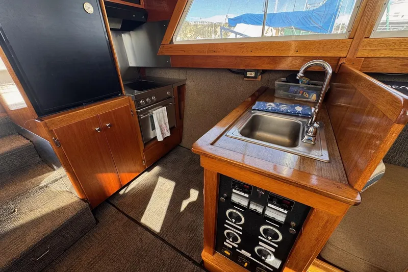 Slide: The Image of Interior of a 1972 Gandy Flybridge boat featuring a compact kitchen with wood cabinetry. - 19
