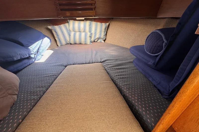 Slide: The Image of 1972 Gandy Flybridge cabin interior with cozy bedding and striped pillows. - 22