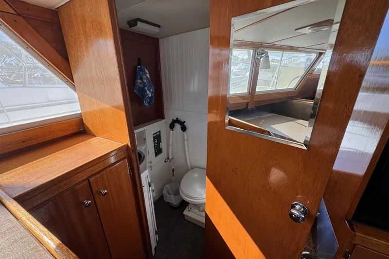 Slide: The Image of Interior of a 1972 Gandy Flybridge boat with wooden cabinetry and a compact bathroom. - 23