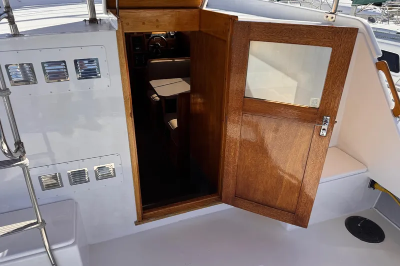 Slide: The Image of 1972 Gandy Flybridge boat interior with open wooden door and visible seating area. - 7