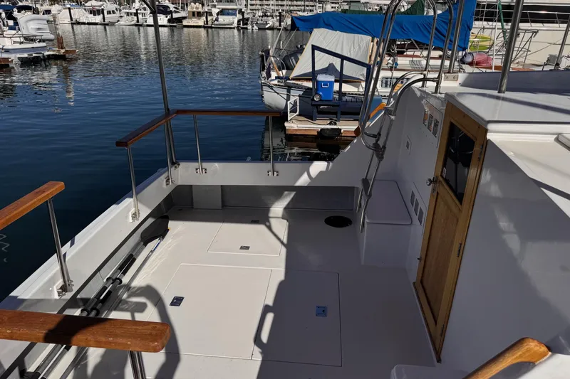 Slide: The Image of 1972 Gandy Flybridge boat deck with wooden railings, docked in a marina. - 8