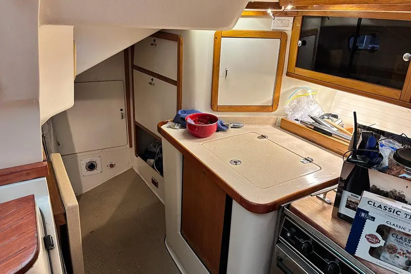 Slide: The Image of Interior of 1999 Catalina 42 MkII sailboat, featuring a compact kitchen area. - 10