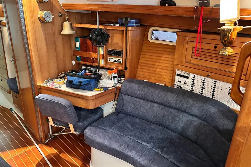 Slide: The Image of 1999 Catalina 42 MkII yacht interior with navigation station and blue seating. - 13